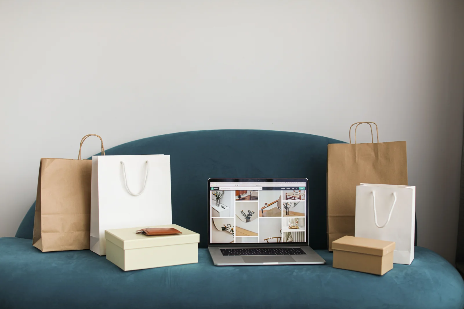 Online shopping bags, packages, and a laptop on a sofa